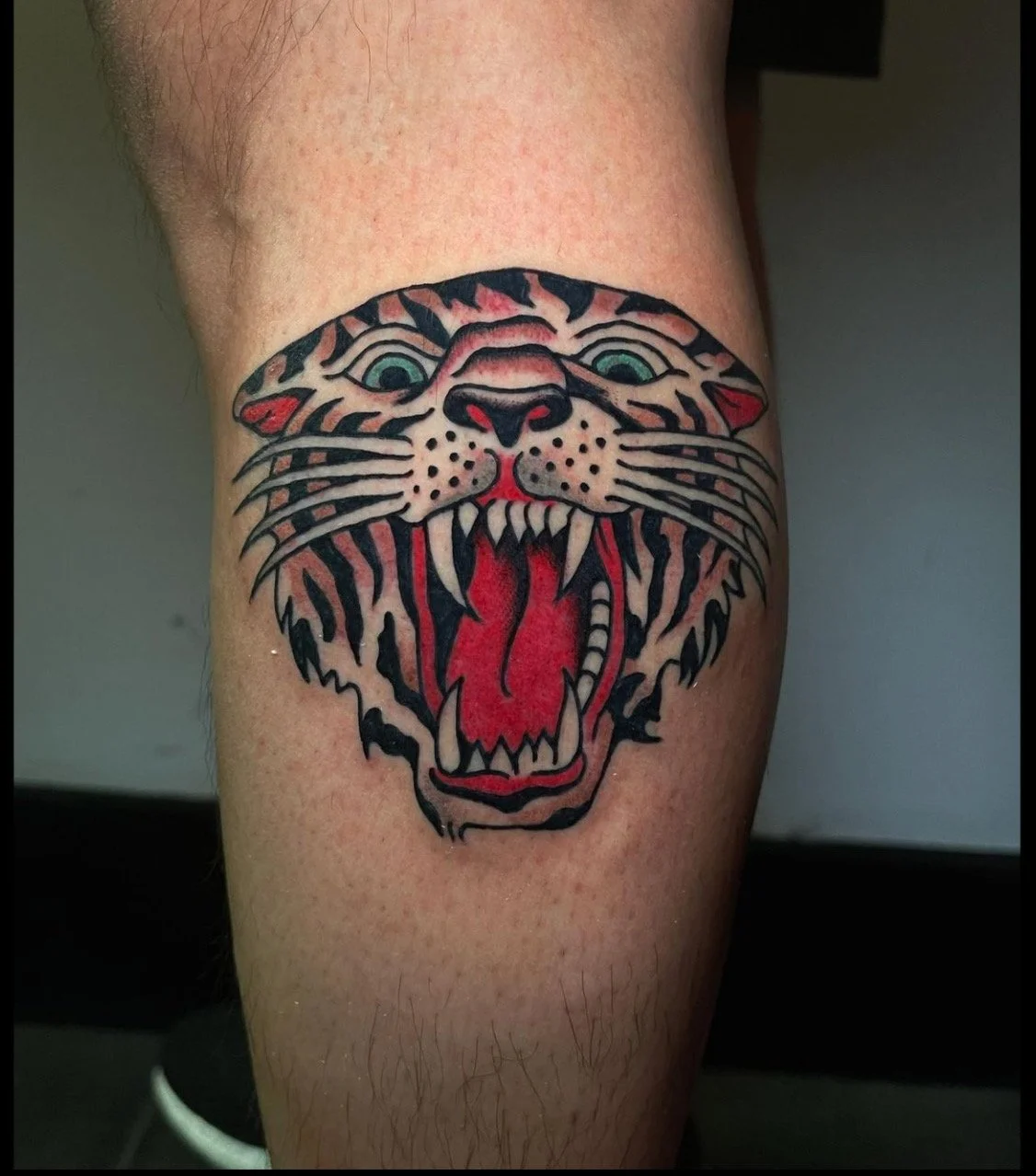  Tattoo of tiger head with open mouth.  