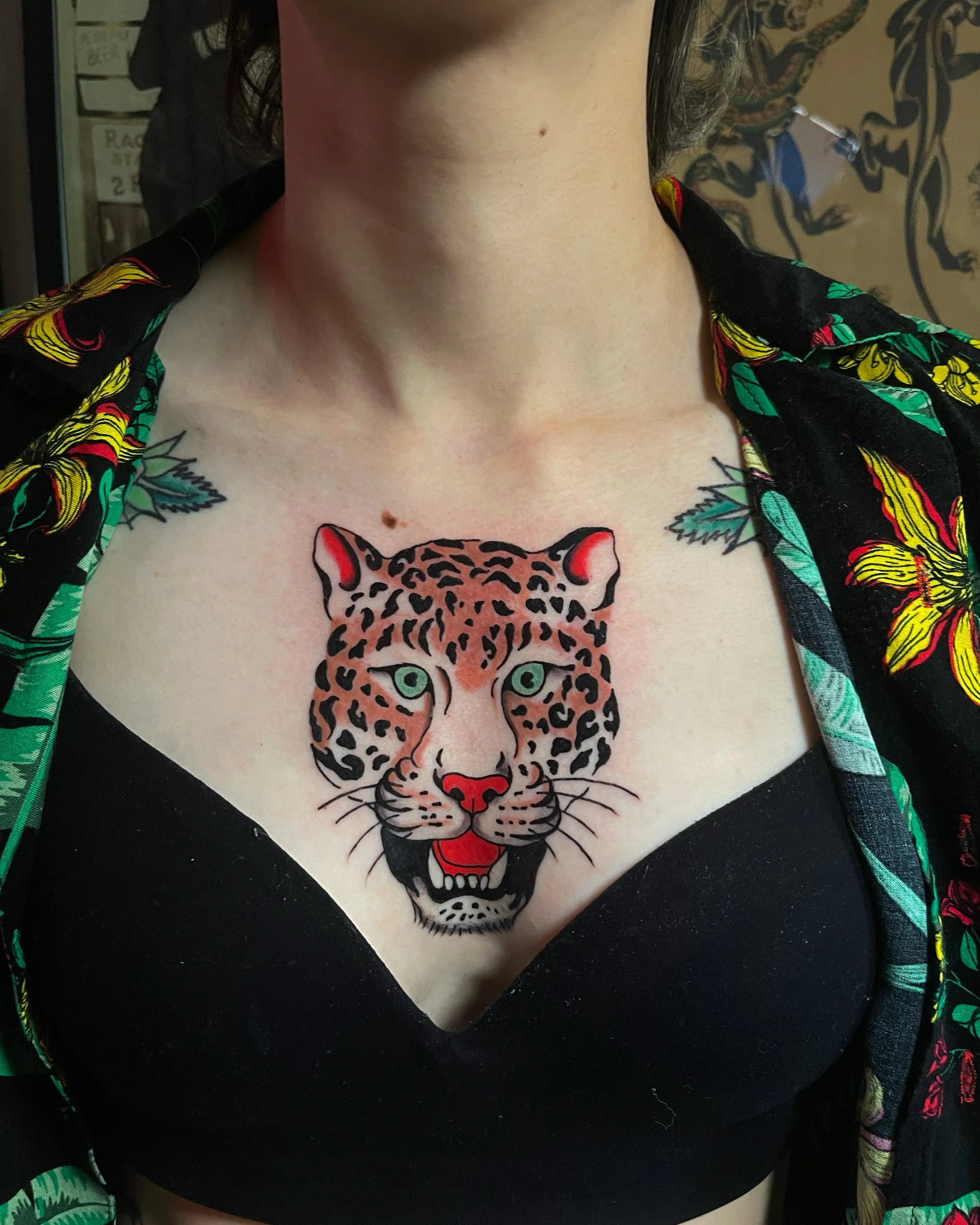  Tattoo of leopard head on chest.  