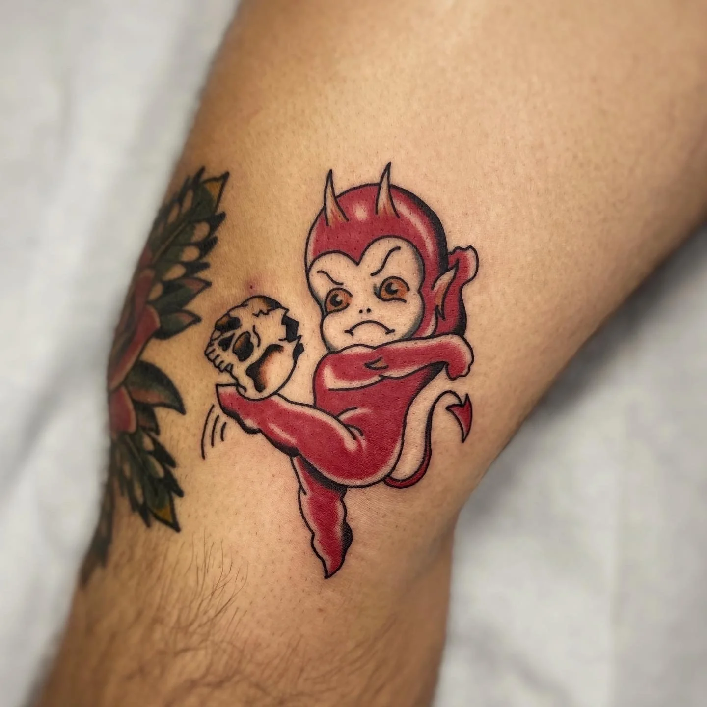 Cherub devil kicking skull