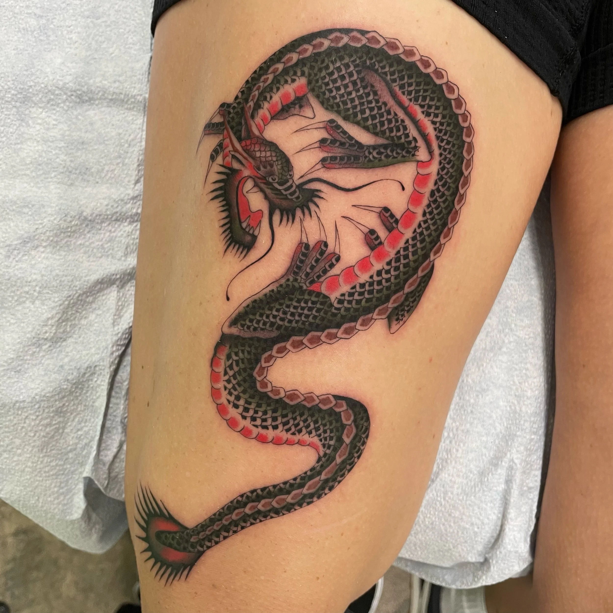 Tattoo of black dragon with red accents