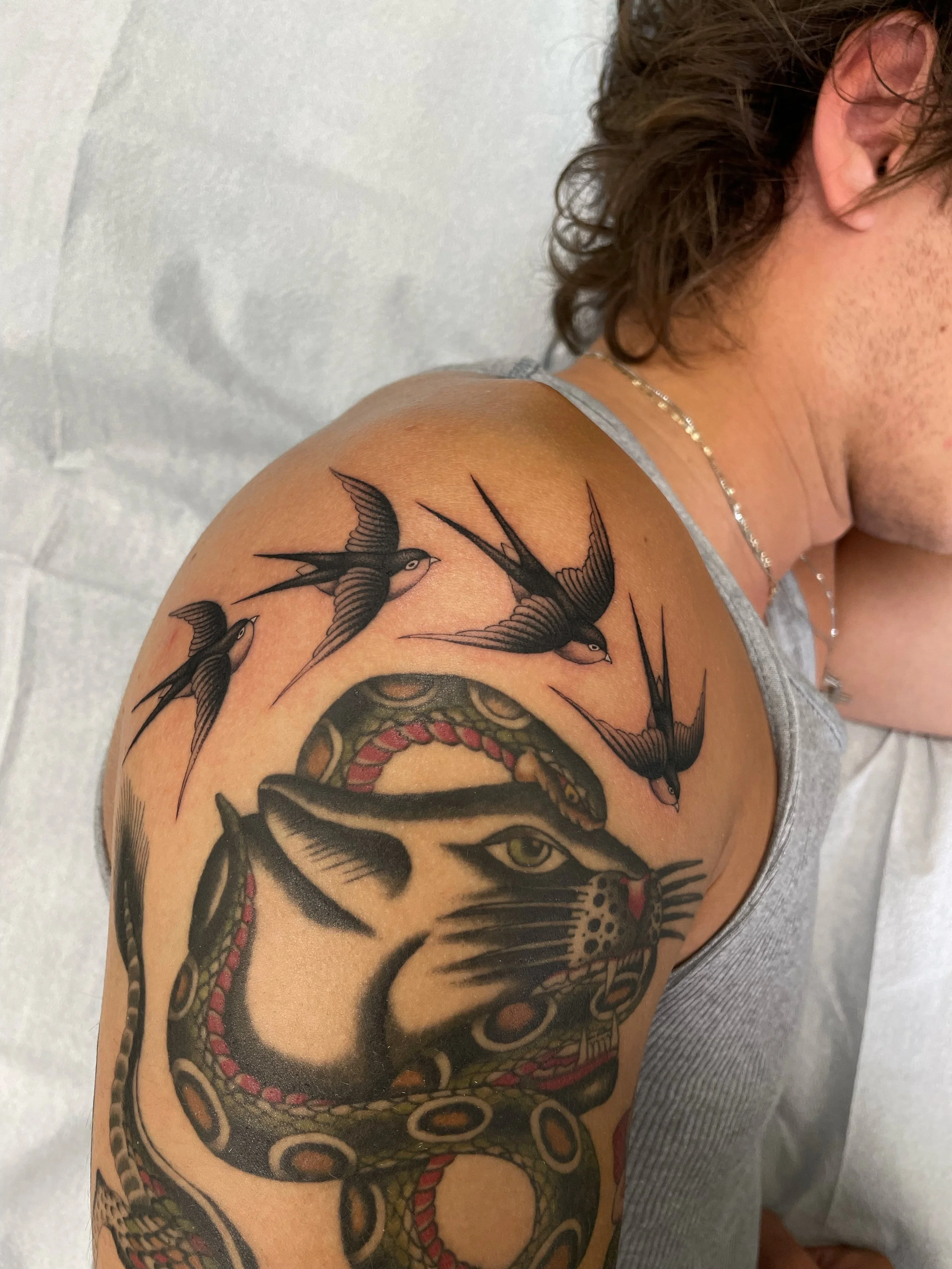 Tattoo of 4 birds flying, framing top of arm
