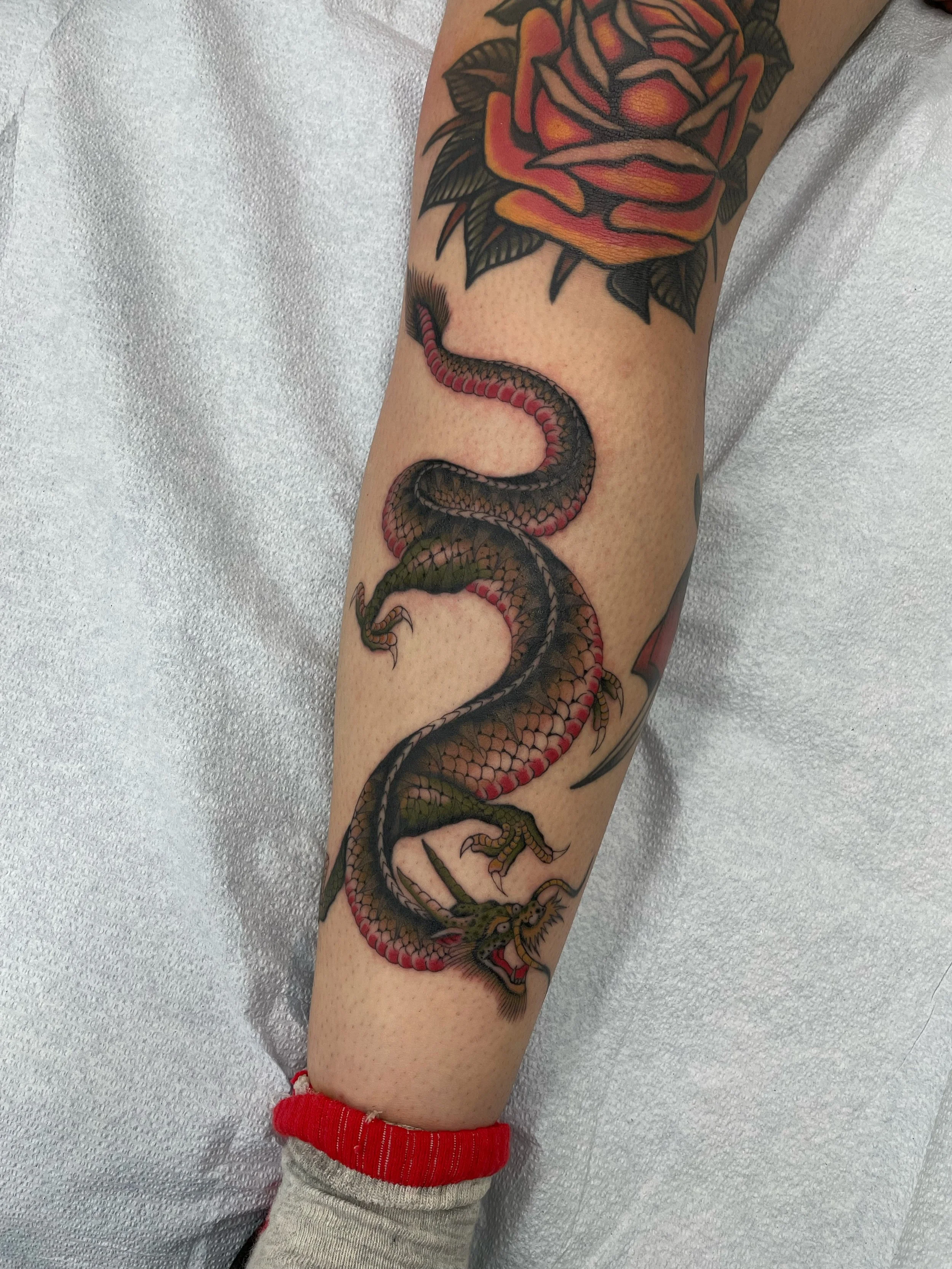 Tattoo of black dragon with red accents