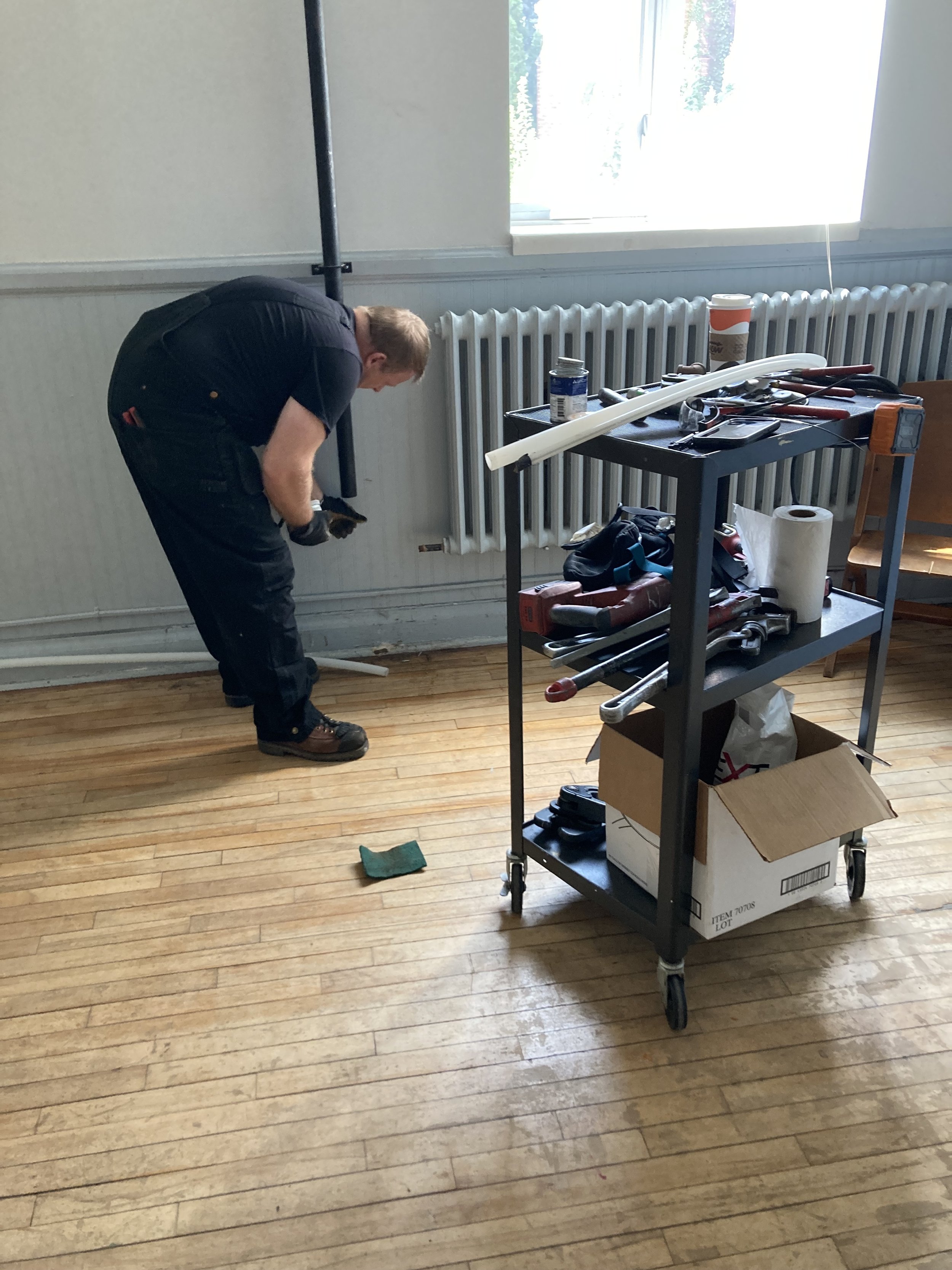 Aaron connecting main pipe to feeders in Celebration Hall.jpeg