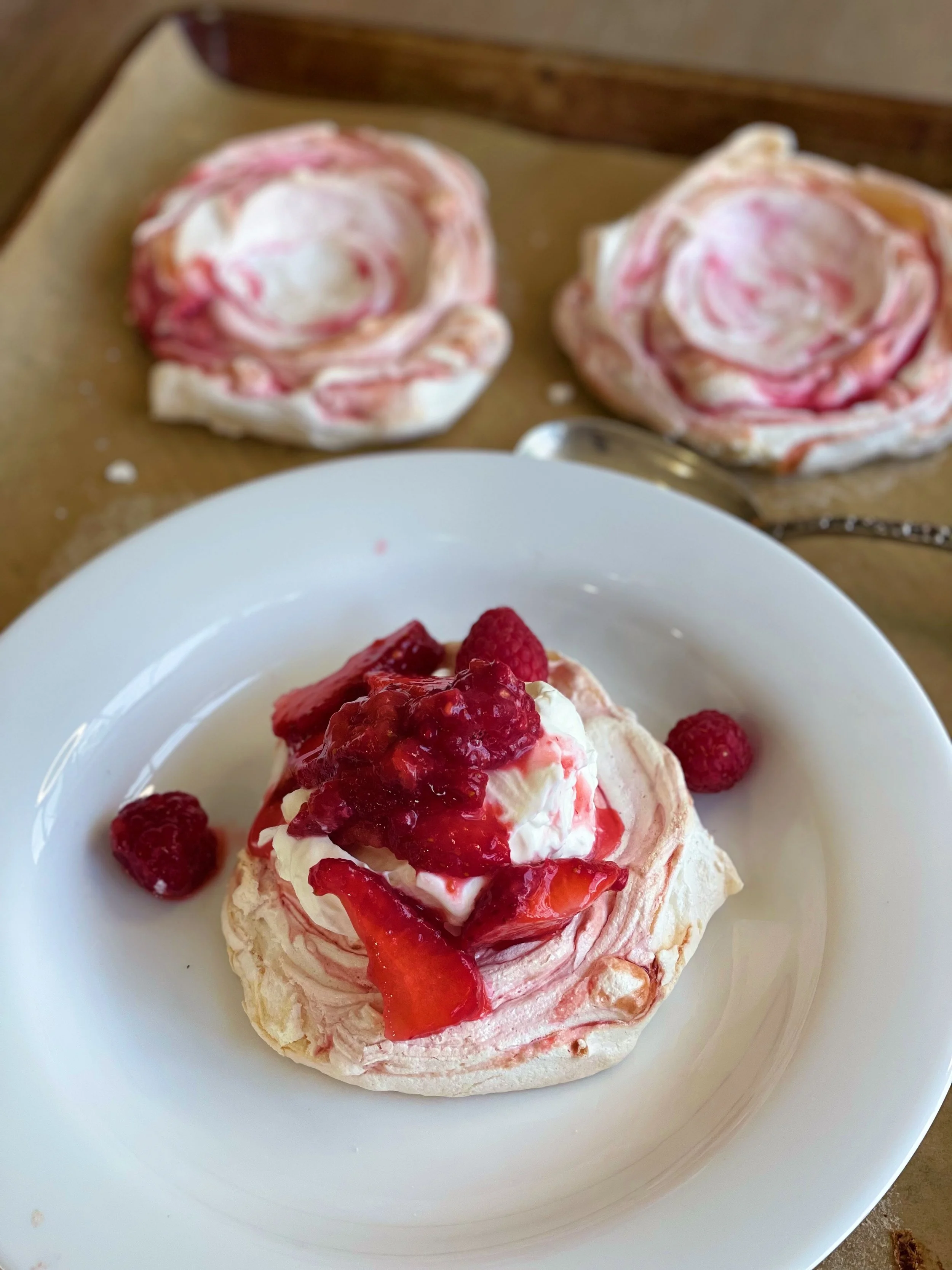 Raspberry Swirled Meringues with Whipped Cream and Berries