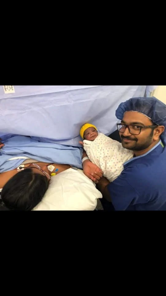 Image: Baby Tarak being held by his very proud father Uma, Mumma Sravya resting on a pillow in theatre. Photo supplied by Sravya