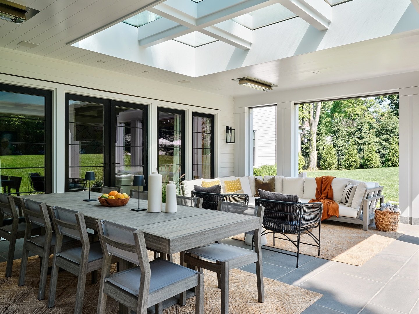 This veranda ceiling houses skylights, space heaters, speakers, lighting, and a drop down tv. Careful layout and planning with the structure allows this to work in tandem with roll down screens in between the columns.