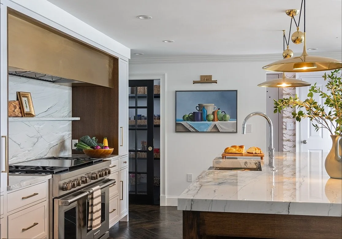A large island for gatherings and a serious cooking station were key for our clients. We achieved this by removing a windowless formal dining room and adding a butler's pantry and enlarged kitchen. A long mudroom was split up to  add a pantry off the