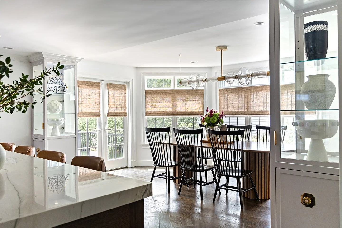 Built-in glass cabinets distinguish the dining space from the kitchen while preserving open views and natural light.