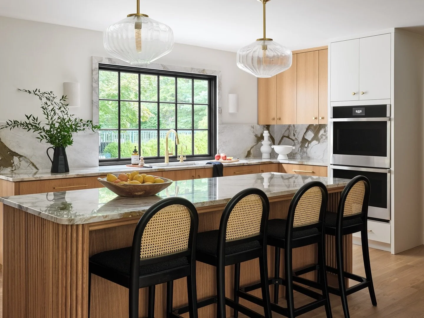 Another angle of our Westport modern kitchen. We mixed white oak stain grade cabinetry to the perimeter with floor to ceiling paint grade cabinetry to add warmth and balance to the space.