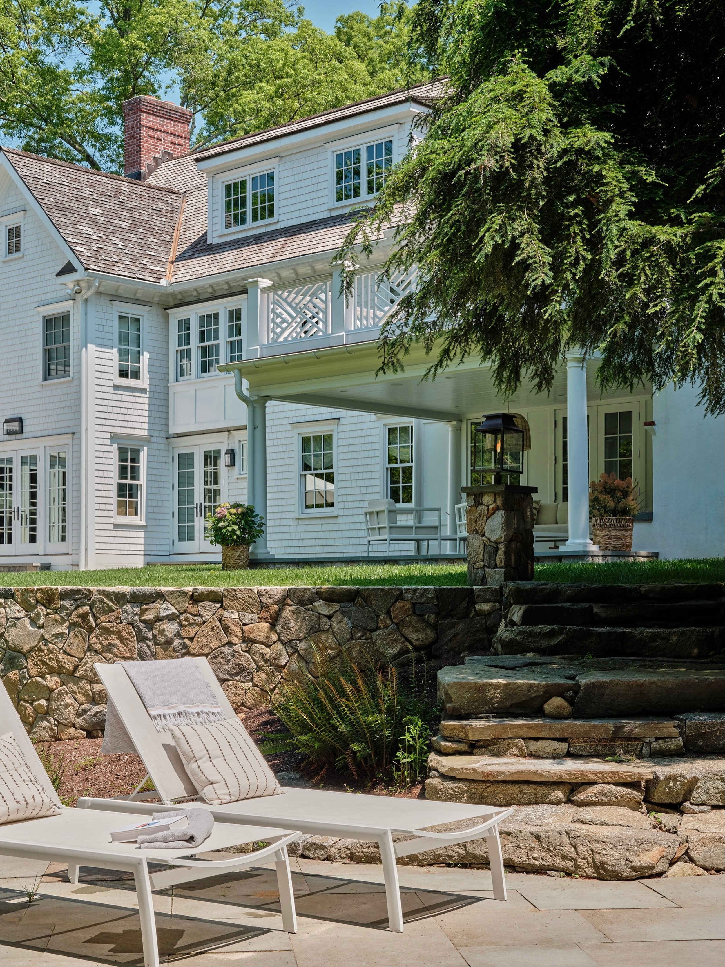 The peaceful &ldquo;after&rdquo; image in Greenwich, CT. 

This renovation included pool restoration and new paving stones, a new retaining wall, new landscaping, and a terrace addition with a walk-out second story deck overlooking the rear yard.
