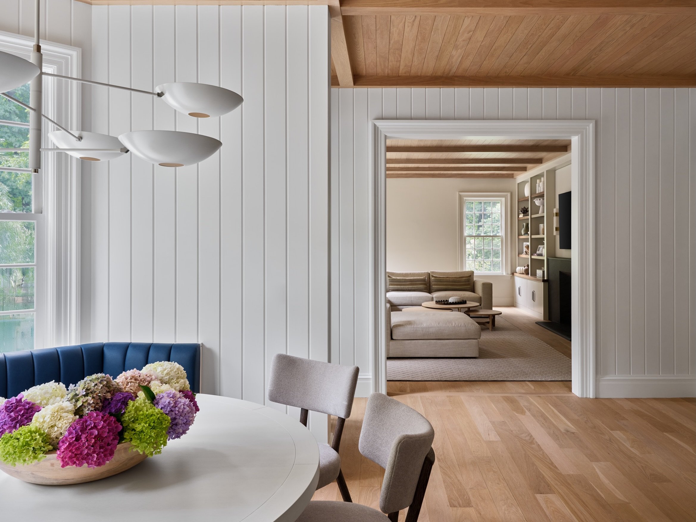 A glimpse from the breakfast room to the family room in Wilton. Butternut paneled ceilings flow from one room to the next to unify the spaces.
