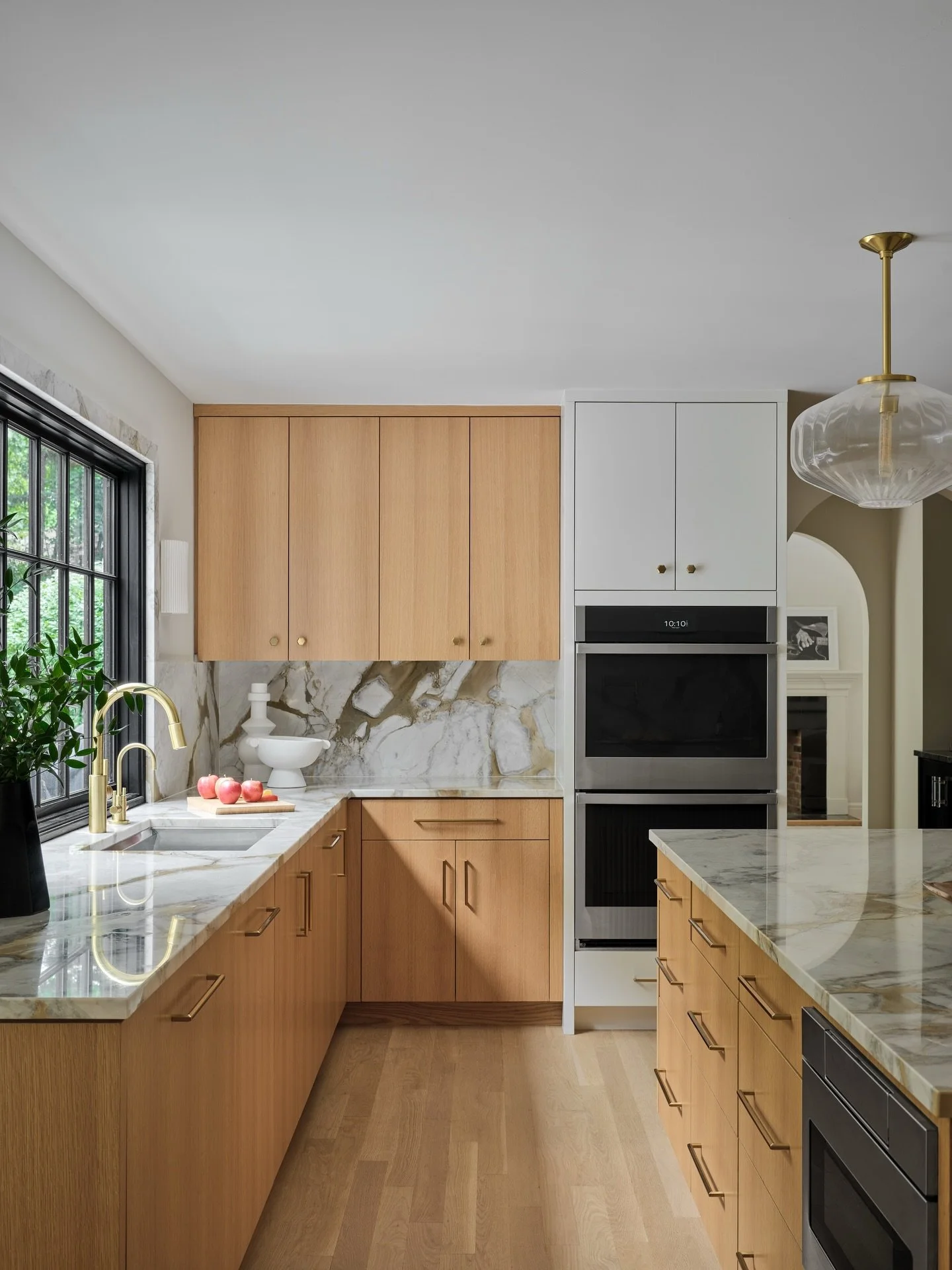A large window in front of the sink with a hardworking island full of storage and appliances makes for a beautiful pairing in our Westport project.