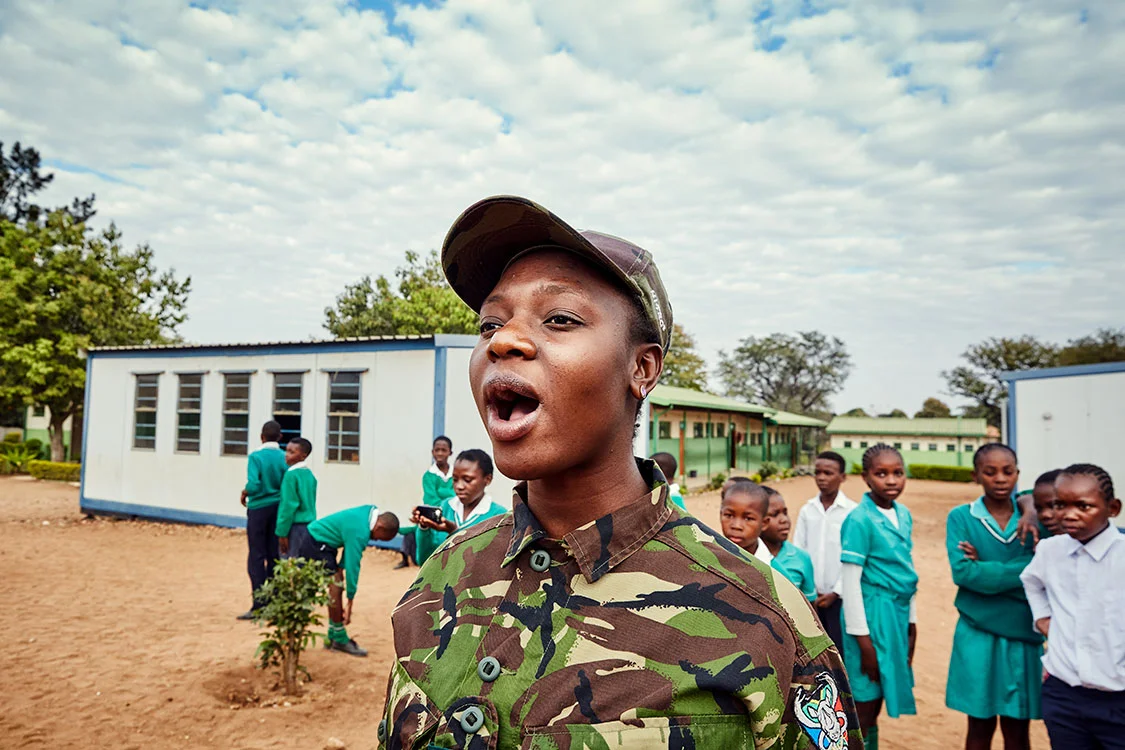 Black Mamba Nkateko Mzimba demonstrates how to shout orders to a group of school children, Foskor Primary School, South Arica, 2017.