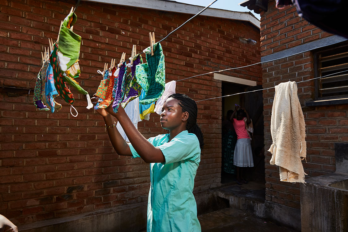 Tamanda hangs up the pads to dry after washing