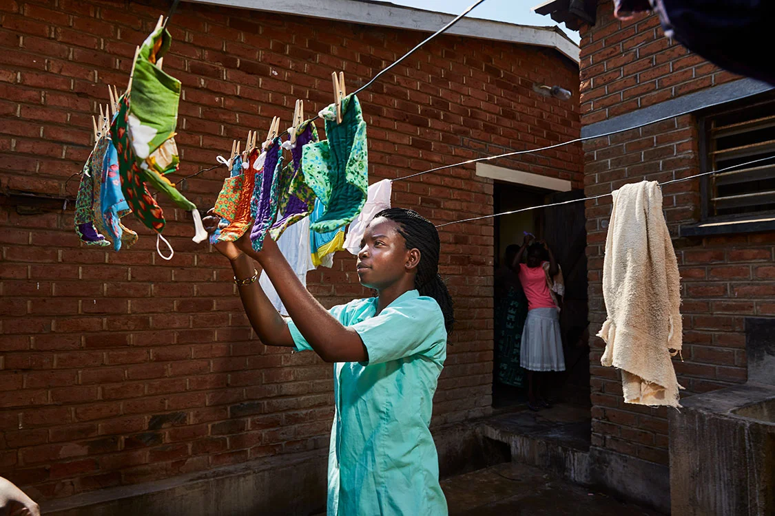 Tamanda hangs up the pads to dry after washing