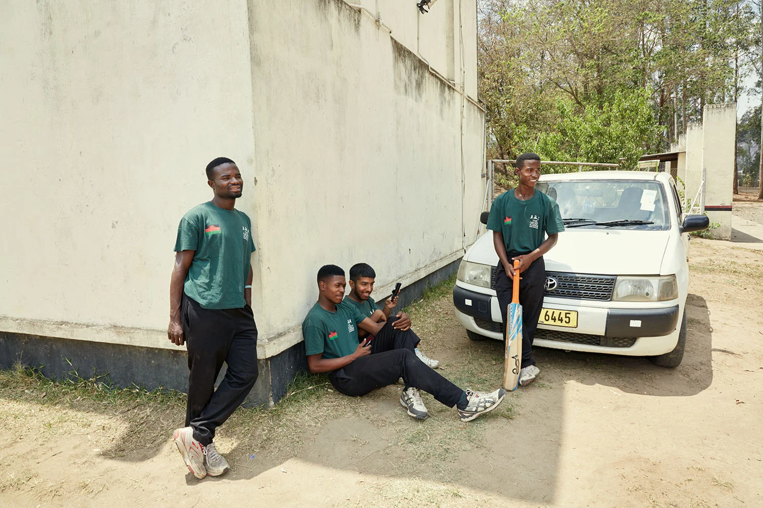 Members of the Malawian National Men’s Cricket Team watch the girls during batting practice, Malawi, 2016.