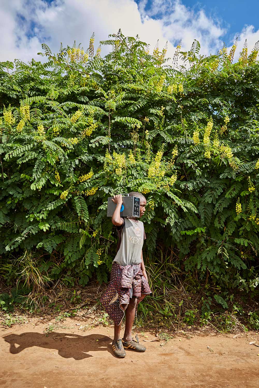  Ben Chumba (10) carries a solar battery home, Chiuta village, Malawi, 2017.  He and his brother return an empty battery and change it for a new one every four days, depending on how much electricity the family uses. 