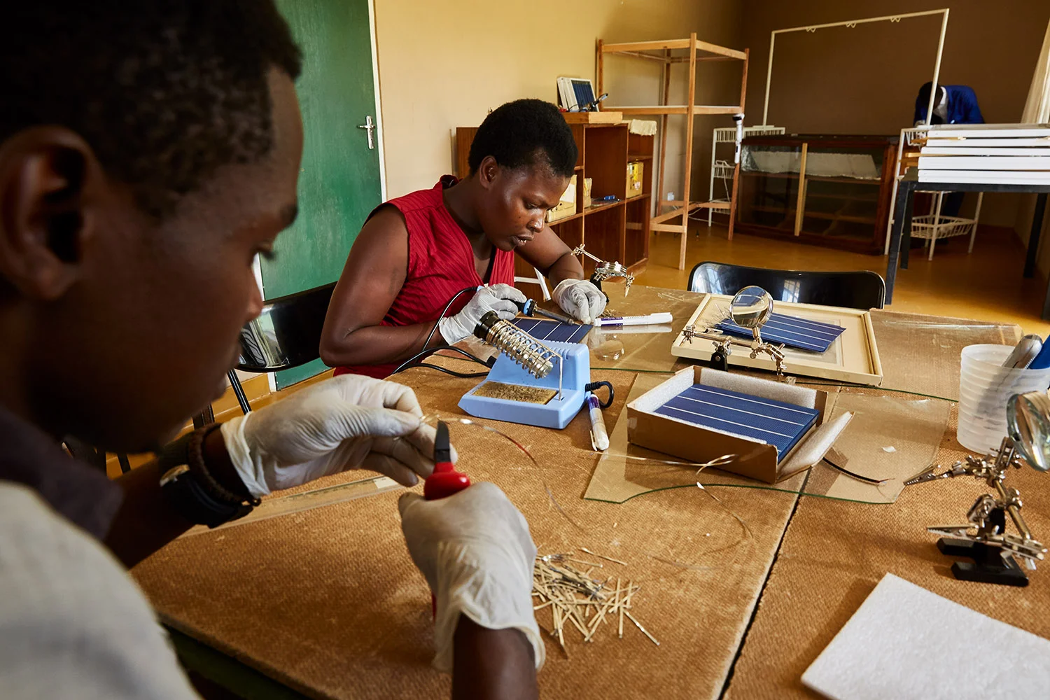 Alex and Jennifer, students at Green Malata, learn how to assemble solar panels, Luchenza, southern Malawi, 2017. Green Malata teaches a variety of renewable energy skills, including solar panel building and maintenance, biogas generation, and wind turbines. As solar panel technology becomes cheaper and easier to use, training villages like Green Malata can afford to not only use them as part of their curriculum, but also to sell and rent them out to local villagers, providing much needed extra income.