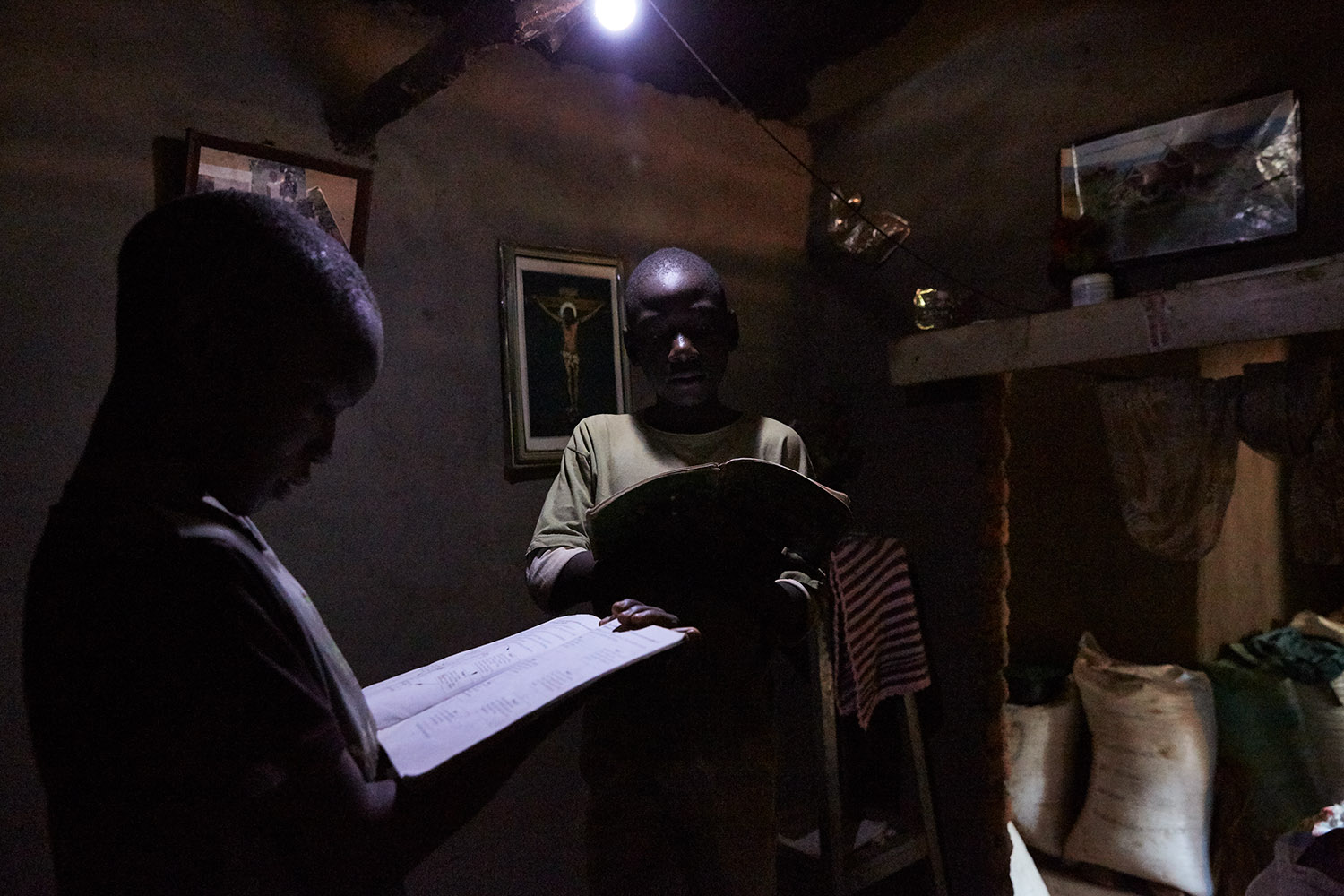  Jan Chumba (12) and his brother Ben (10) studying at home with the solar battery powered light, Luchenza, Malawi, 2017. 