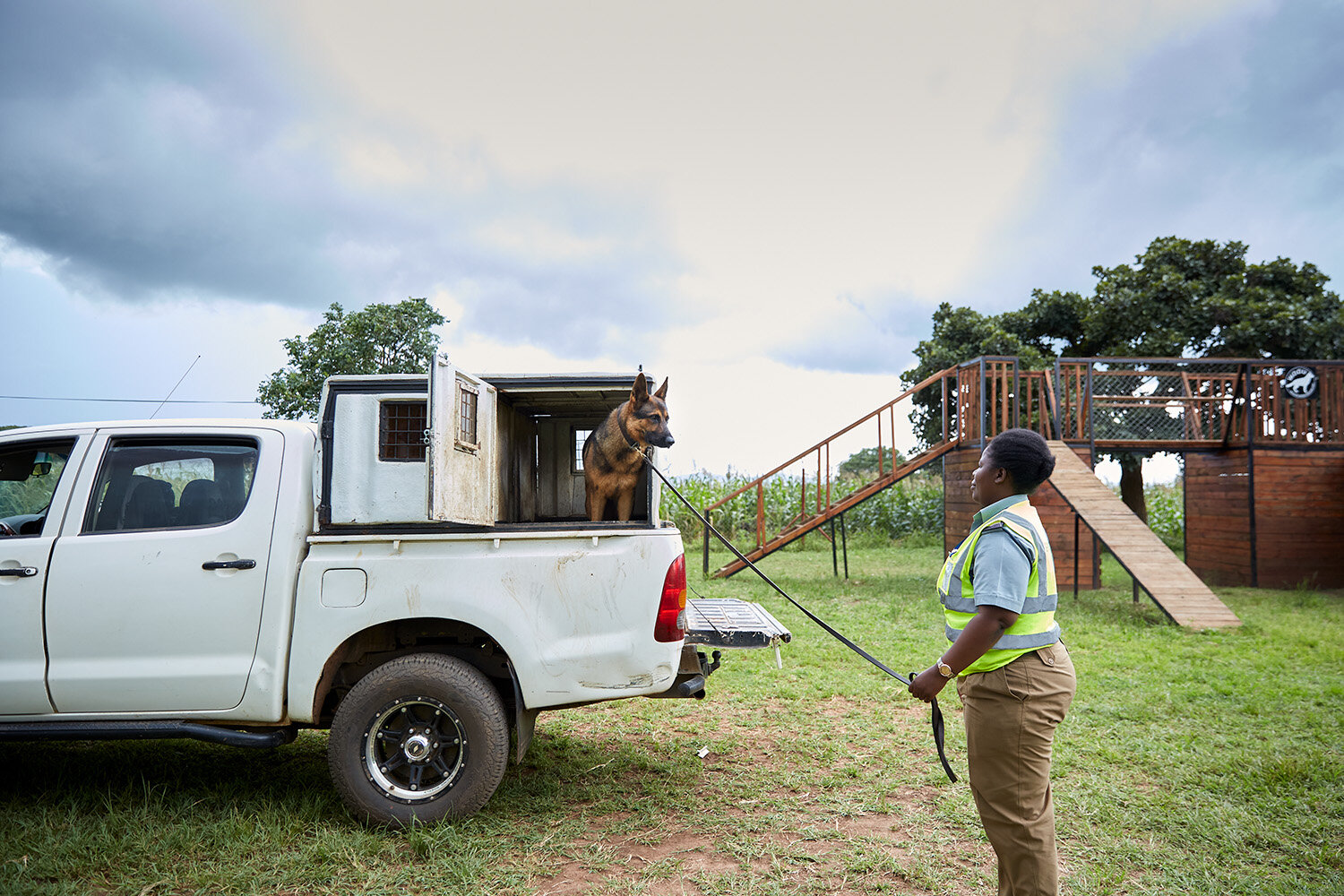  Back at base, Wildlife Detection Dog Unit handler Agnes waits for dog Max to exit the unit’s transport vehicle after their shift is over, Lilongwe, Malawi, 2020. 