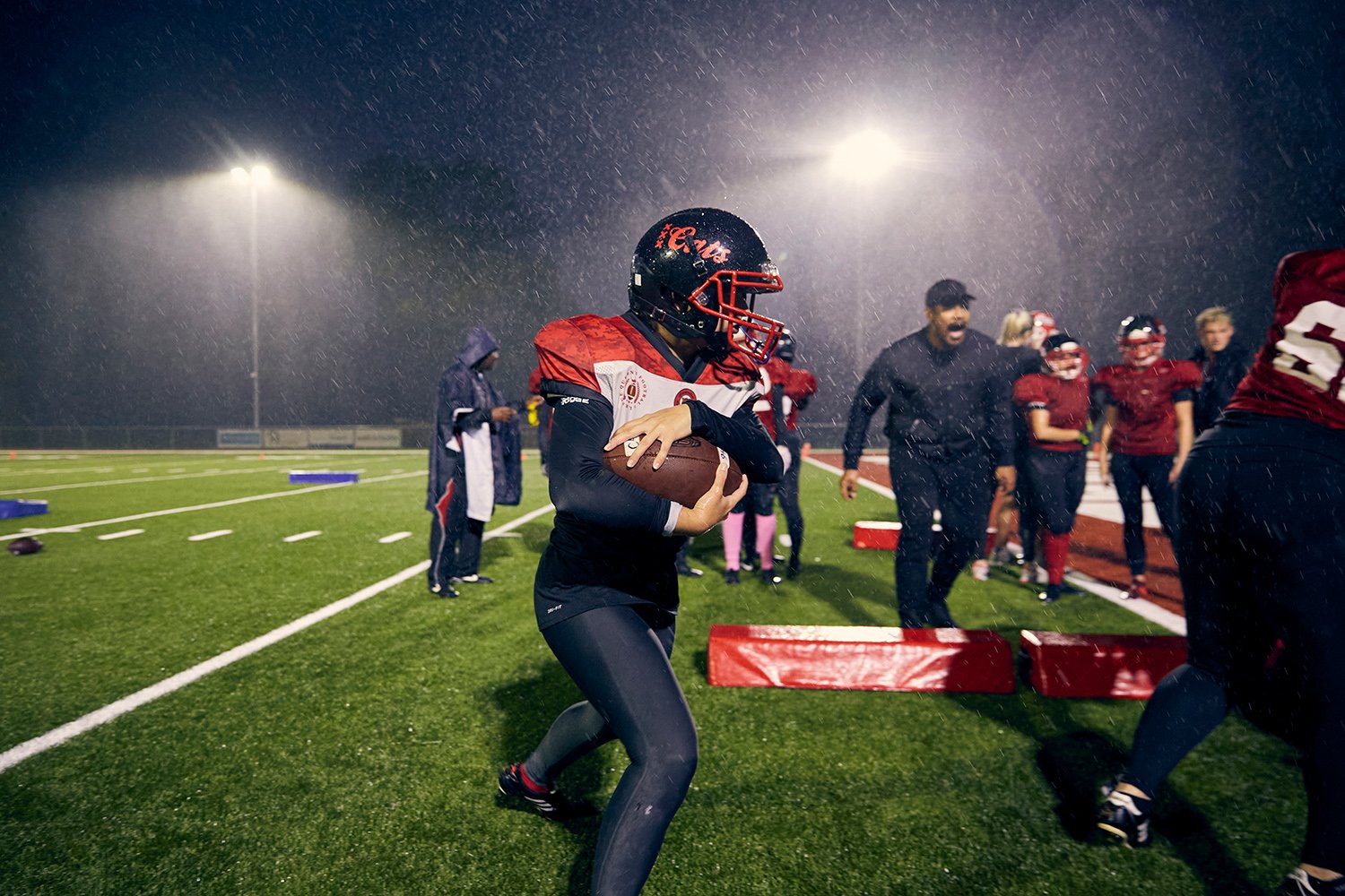  Kelly, the quarterback for the Amsterdam Cats, runs with the ball during a rain-soaked training session, Amsterdam, NL, 2020. 