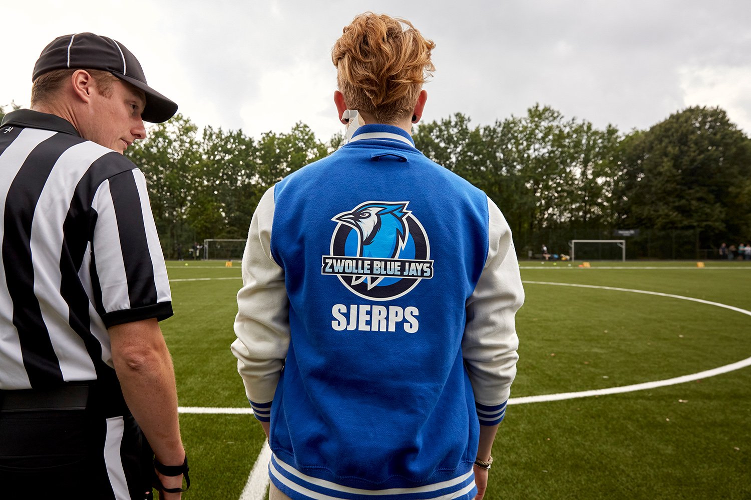  Wearing her team jacket with her last name on the back, Dominique talks to a referee during the first game of 2021 between Zwolle Blue Jays and Utrecht Wolverines, Utrecht, NL, 2021. 