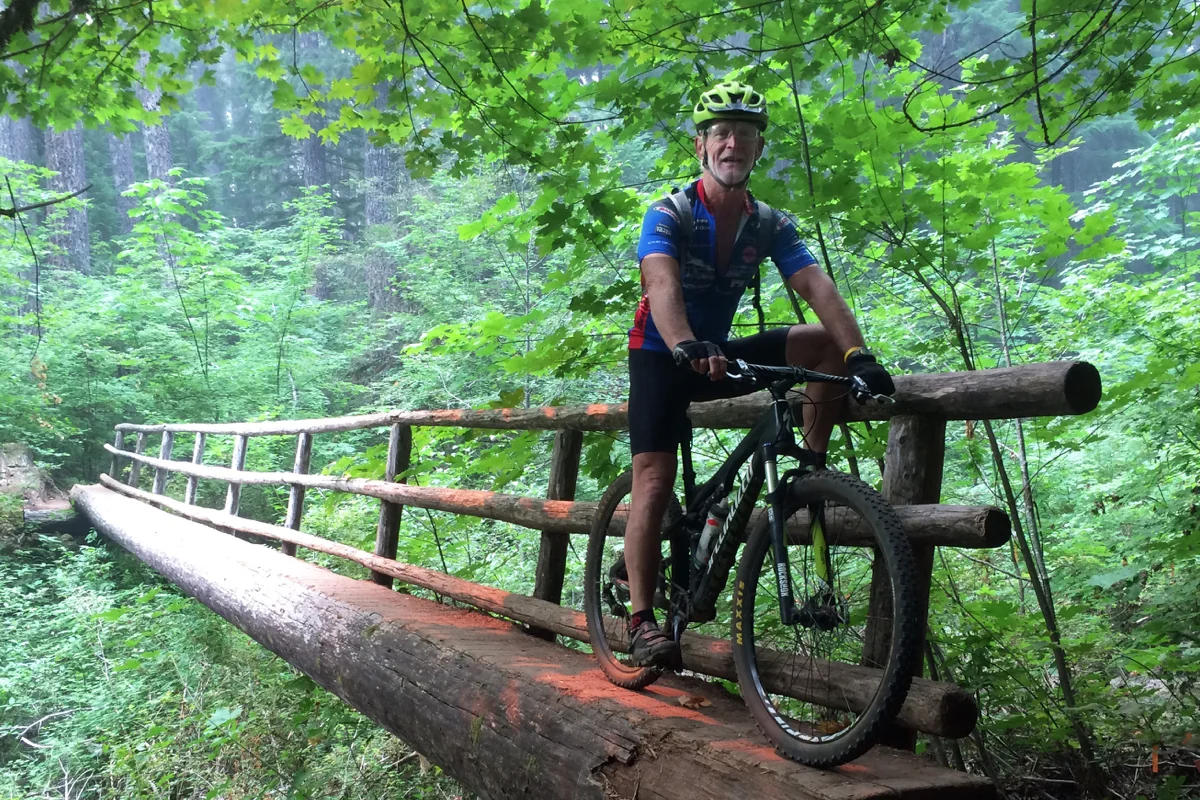Bob Robinson, author of three bicycle guidebooks, crosses one of several single log bridges that crossed lower wetland areas on the McKenzie River Trail.