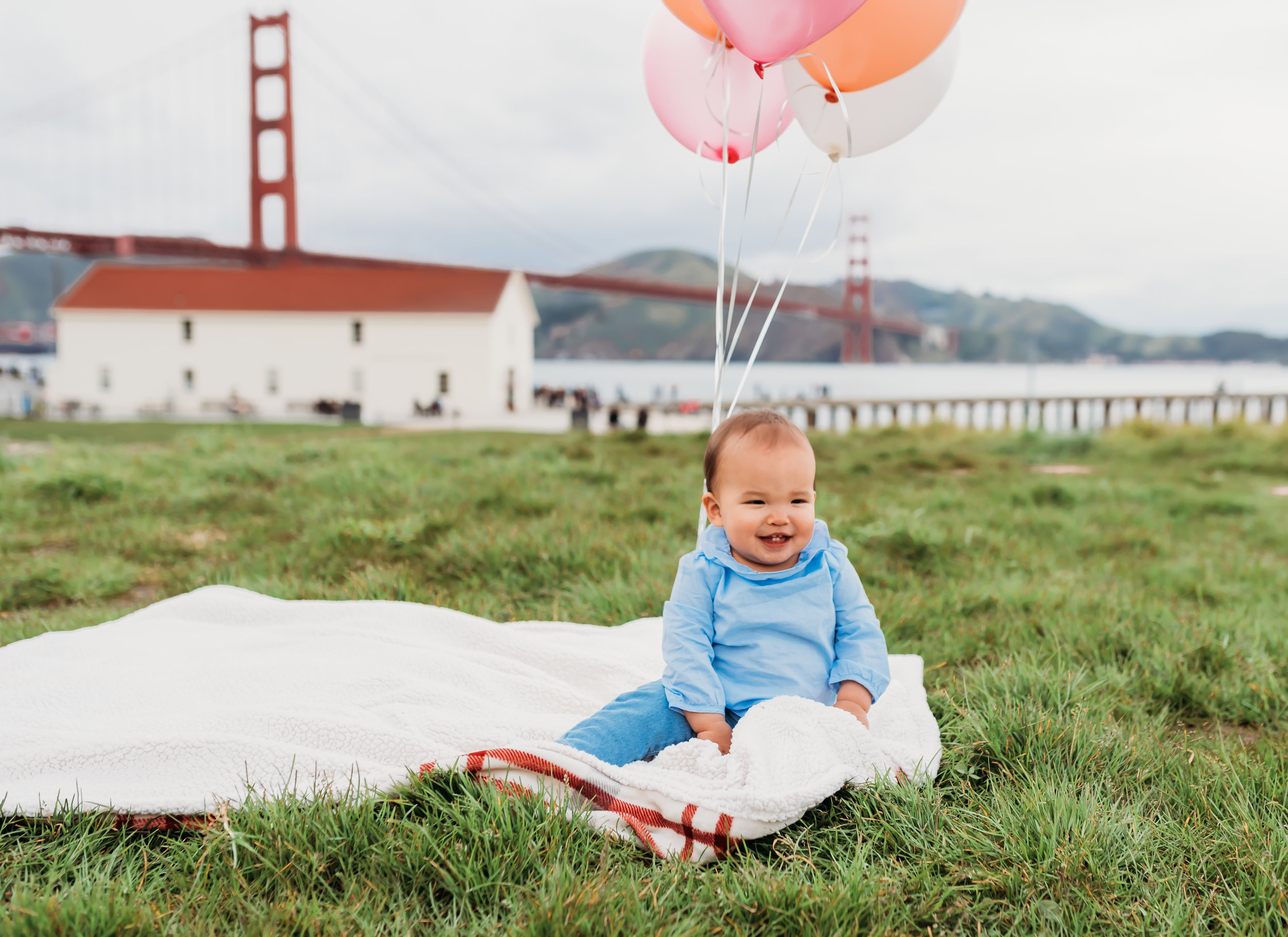 White blanket and pink and white balloons at Crissy Field
