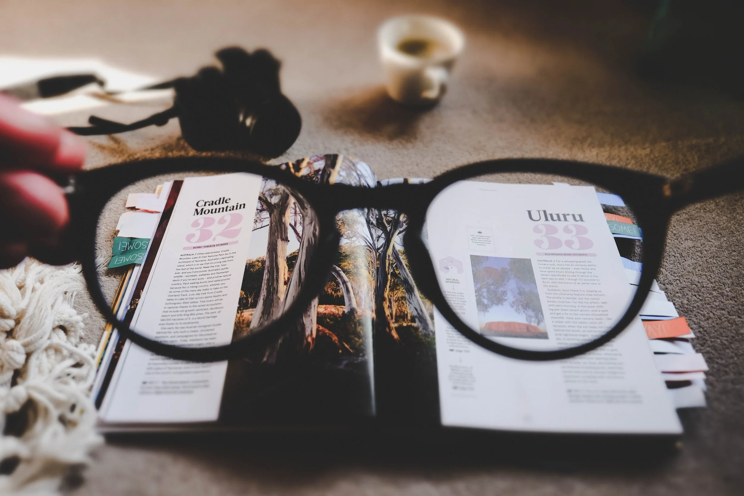 Glasses held above the book, Not knowing mind is always curious, Photo by Ewan Robertson.jpg