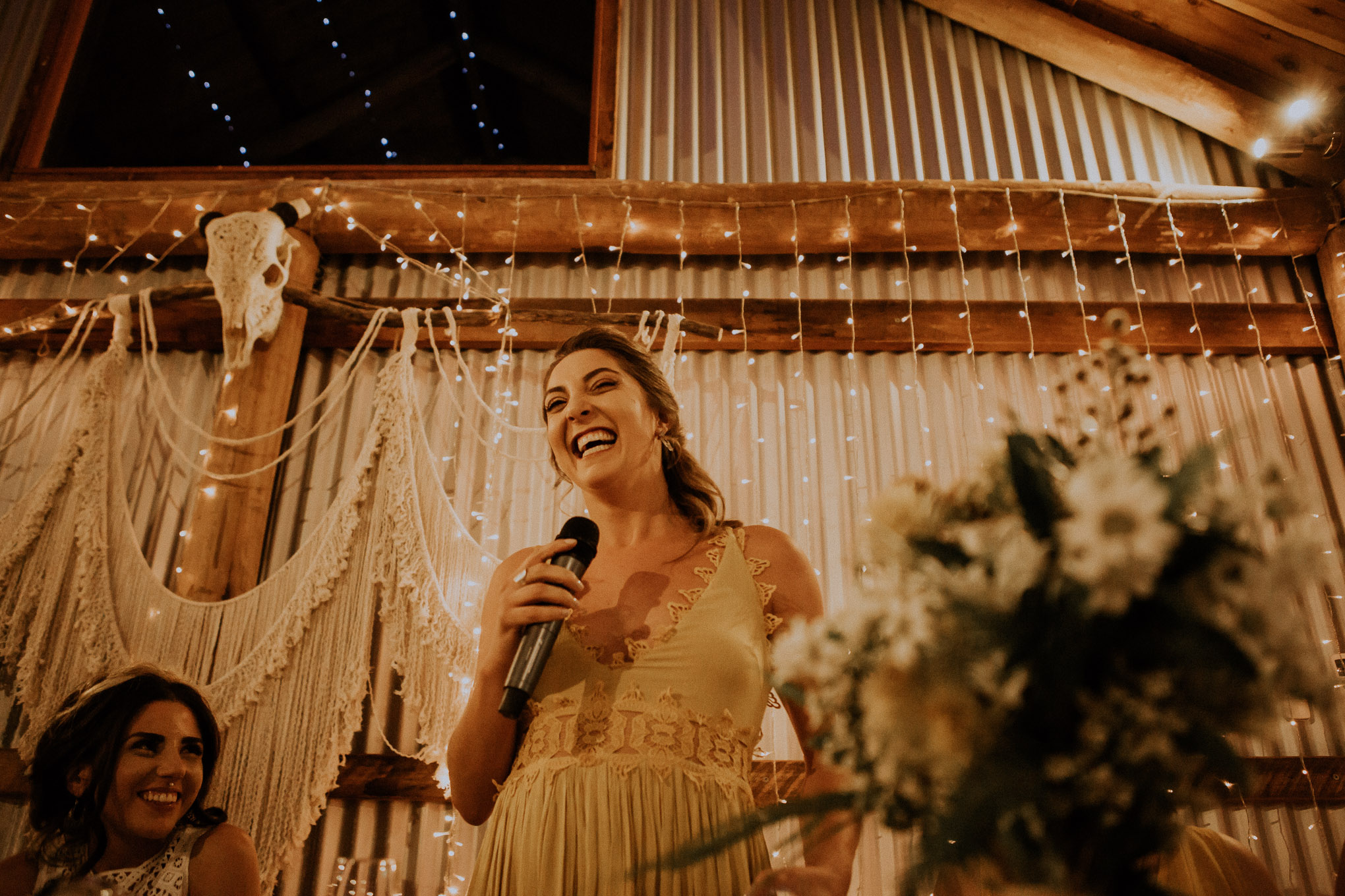 Emotional speeches during a heartfelt wedding ceremony, with fairy lights and macrame