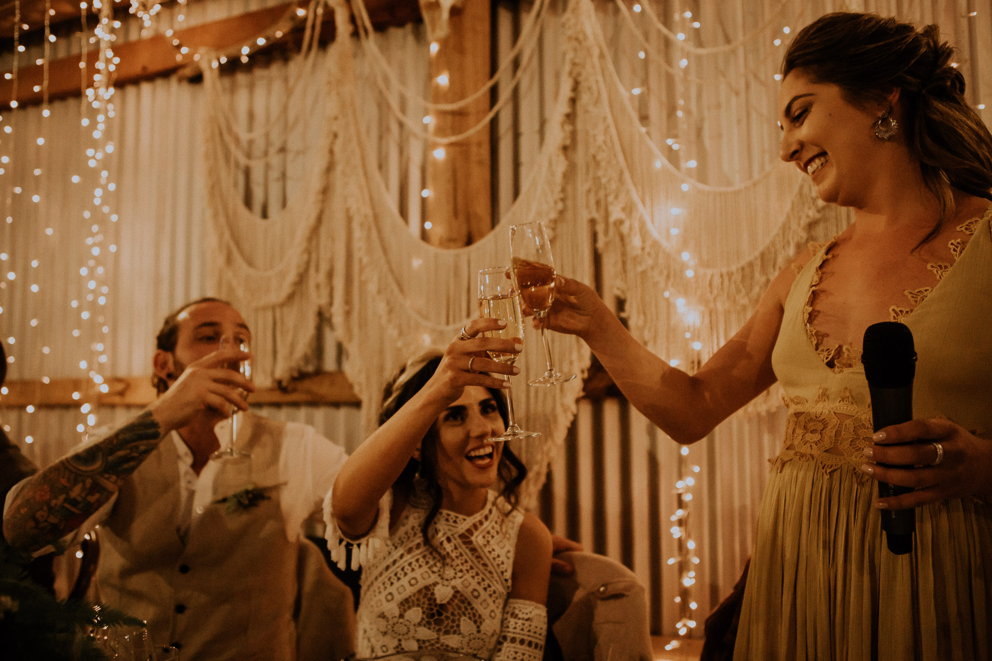 Emotional speeches during a heartfelt wedding ceremony, with fairy lights and macrame