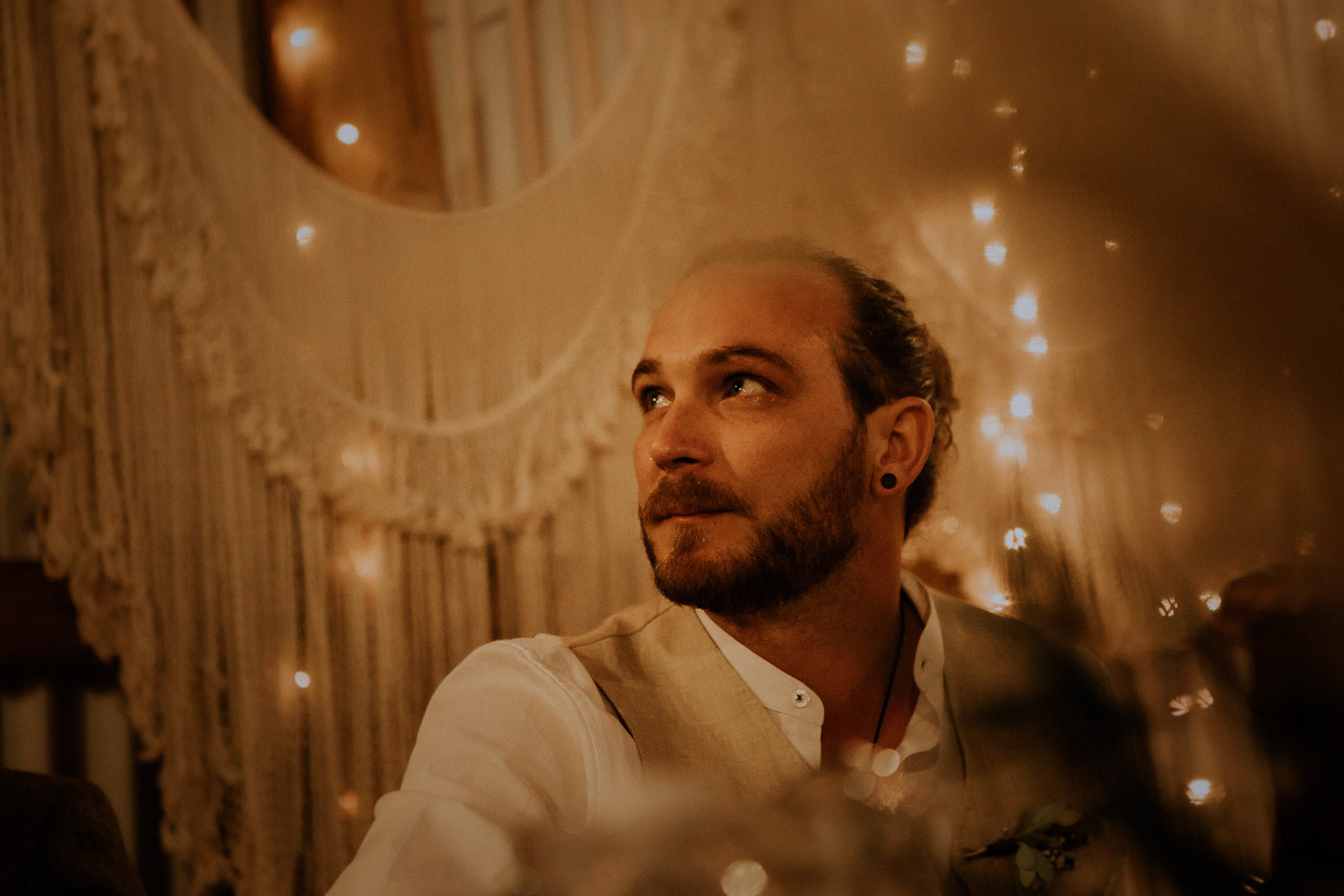 Emotional speeches during a heartfelt wedding ceremony, with fairy lights and macrame