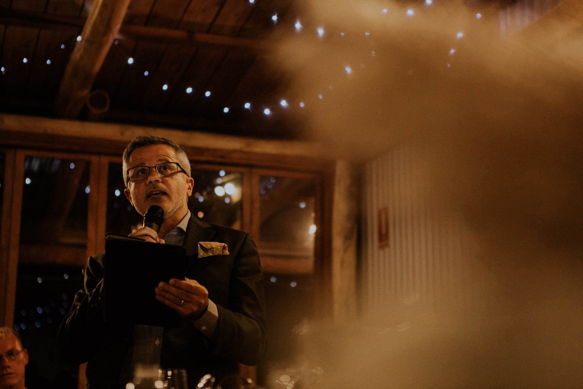 Emotional speeches during a heartfelt wedding ceremony, with fairy lights and macrame