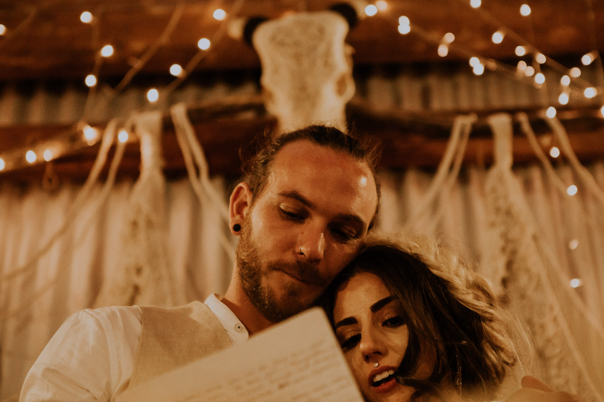 Emotional speeches during a heartfelt wedding ceremony, with fairy lights and macrame