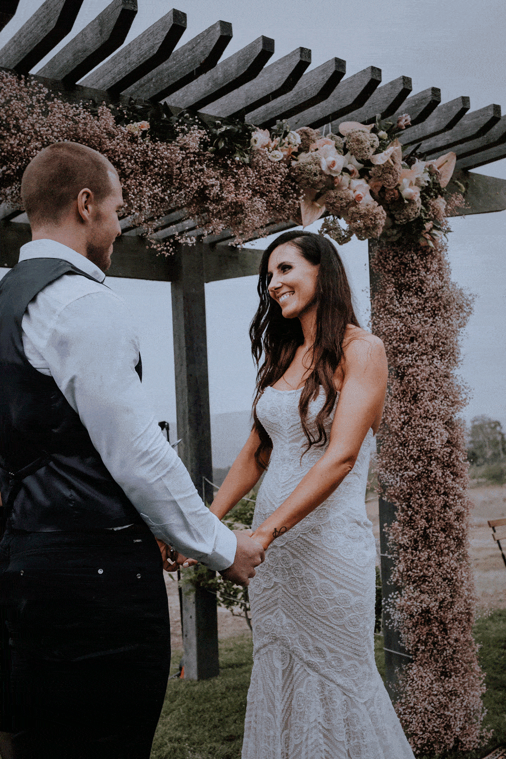 A stop-motion picture of a bride and groom’s first kiss during their rainy outdoor wedding ceremony at Seclusions Blue Mountains
