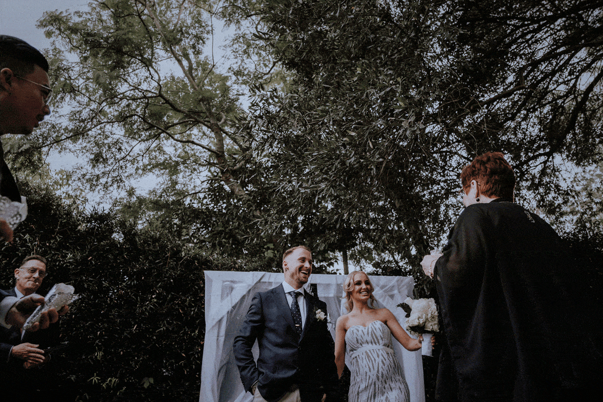 Newly married husband and wife walk back down the aisle and celebrate with flower petal confetti throws