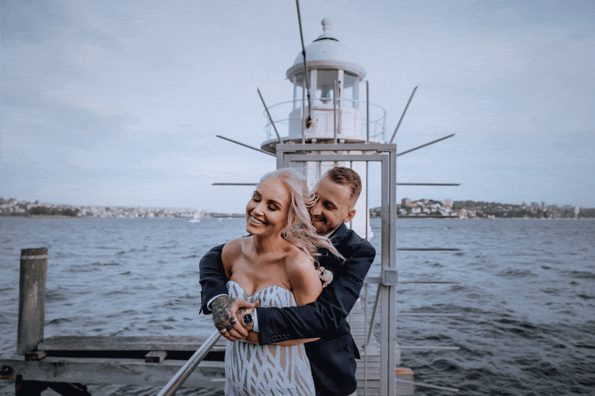 A newly married bride and groom by the lighthouse at Bradley's Head, by Sydney Harbour, at sunset