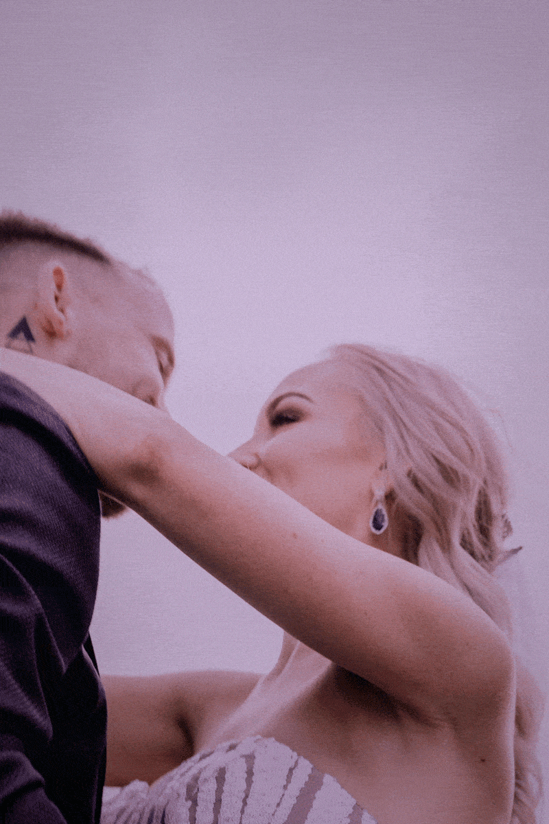 An intimate frame of a newly married bride and groom at Bradley's Head, on Sydney Harbour, at sunset