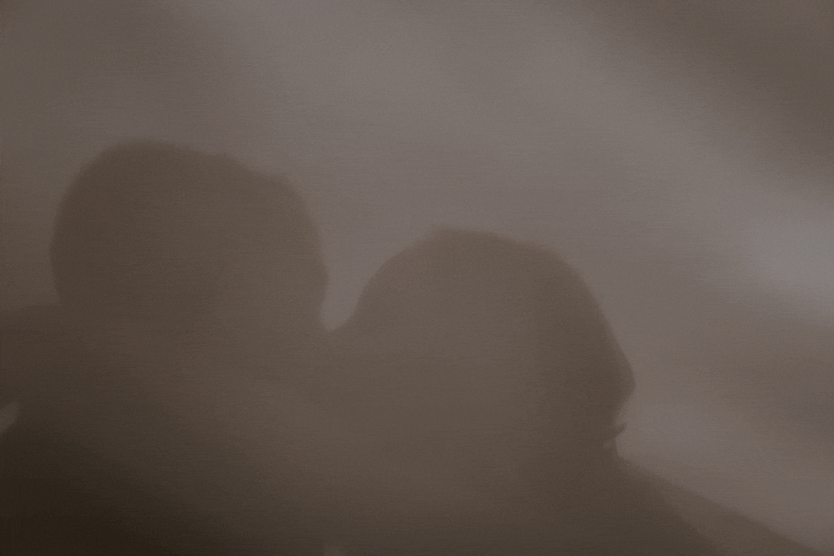An intimate frame of a newly married bride and groom at Bradley's Head, on Sydney Harbour, at sunset