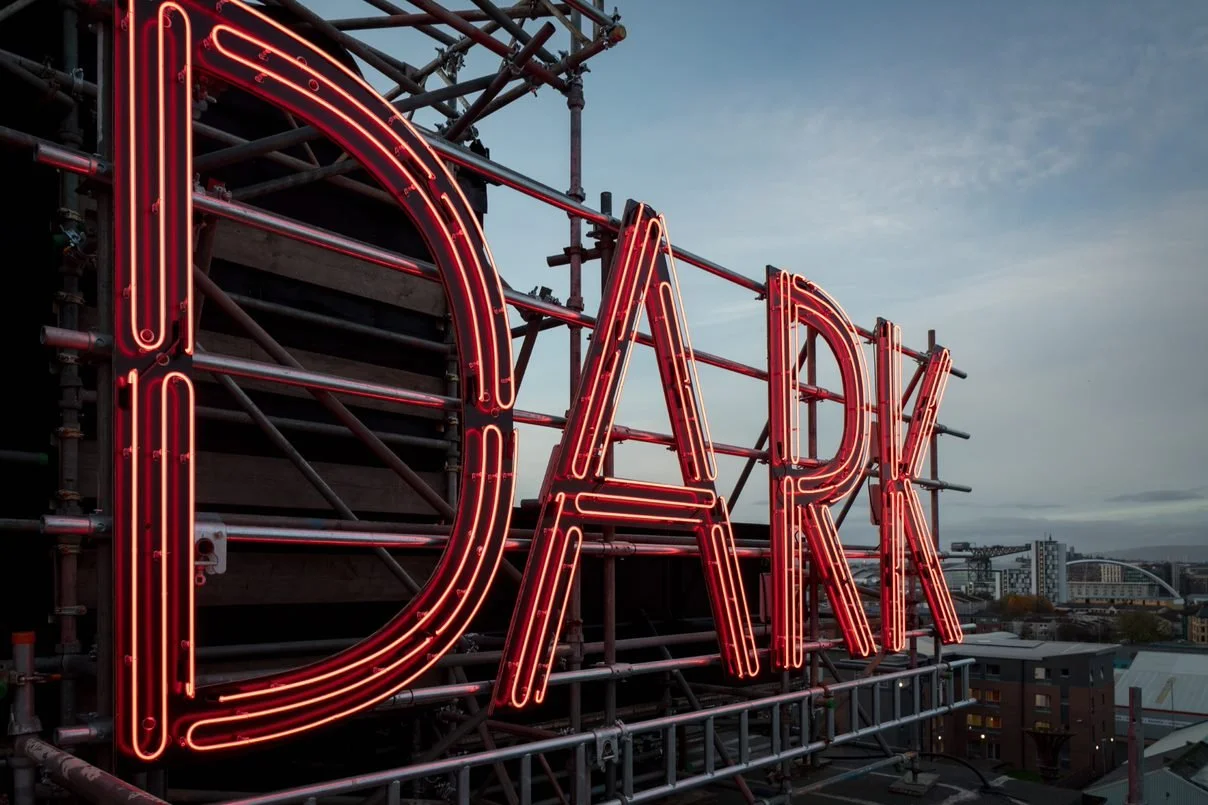 large red neon letters spelling out the word dark
