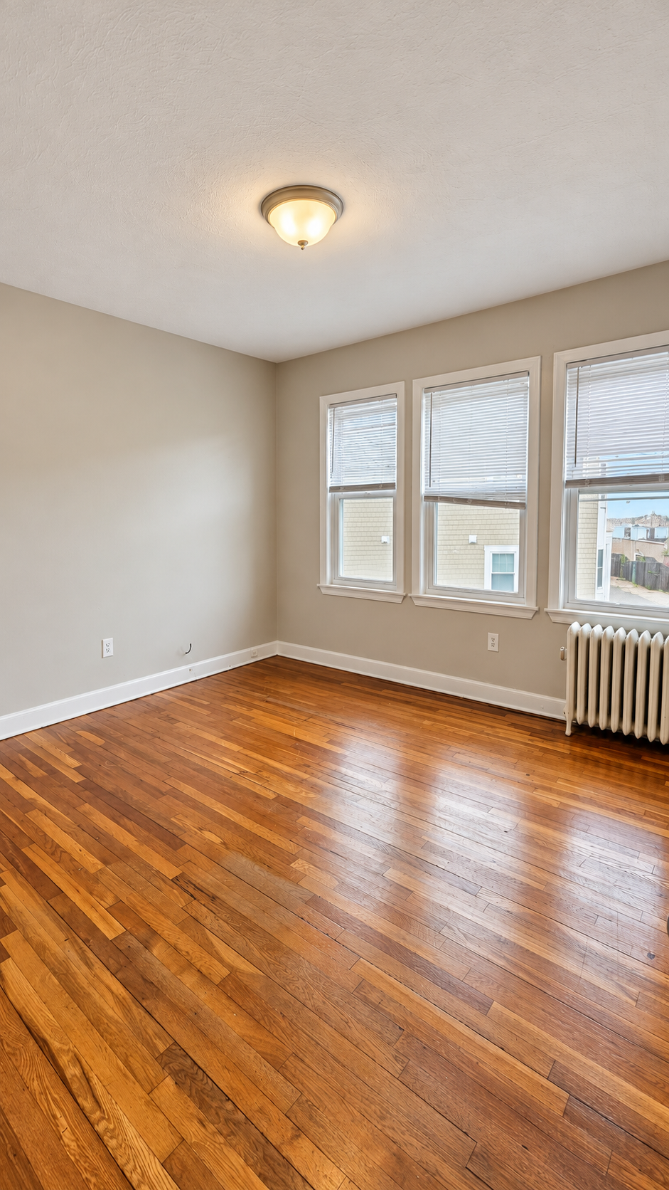bright_empty_room_with_hardwood_floors.png