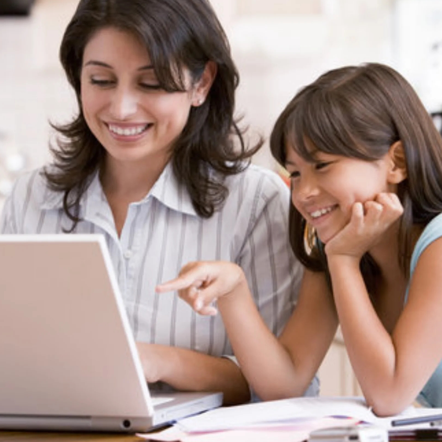 Mom and young daughter working on a computer together.