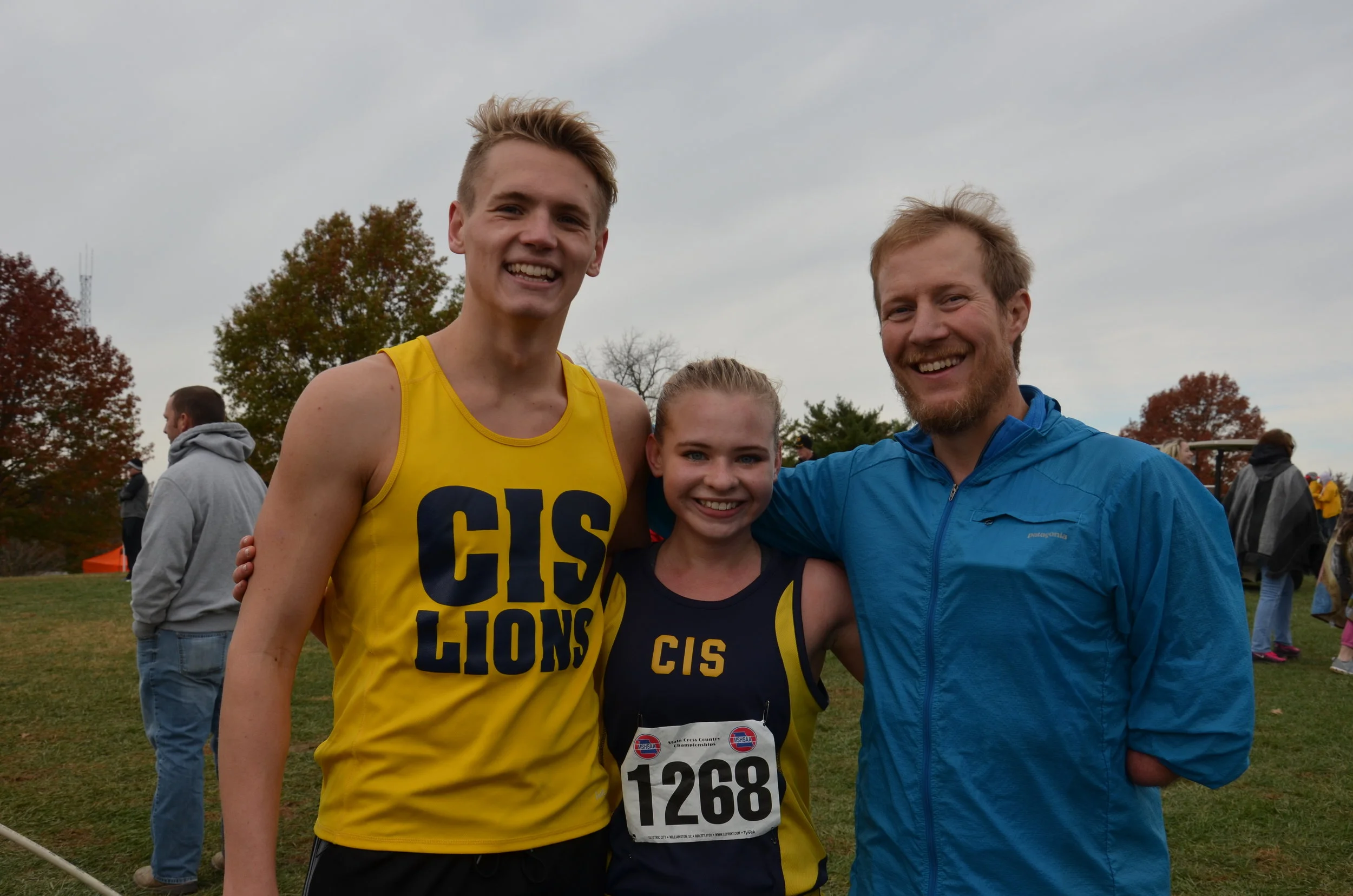 Above: Rowan Musick, Lila Nittler, and Coach Burden come together to celebrate their success in the state cross country meet.