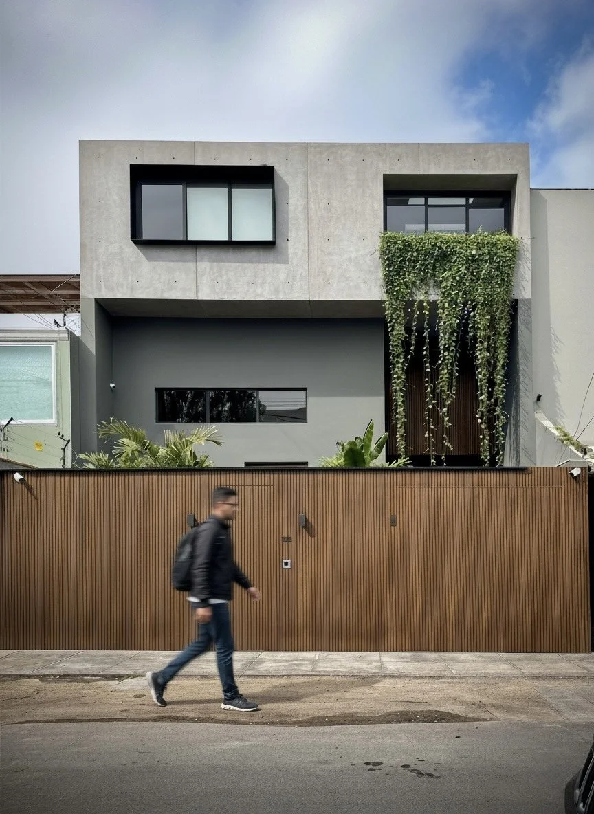 Casa Aurora en Miraflores – fachada de concreto expuesto con trepadoras y cerco de listones de madera – ECKE arquitectos