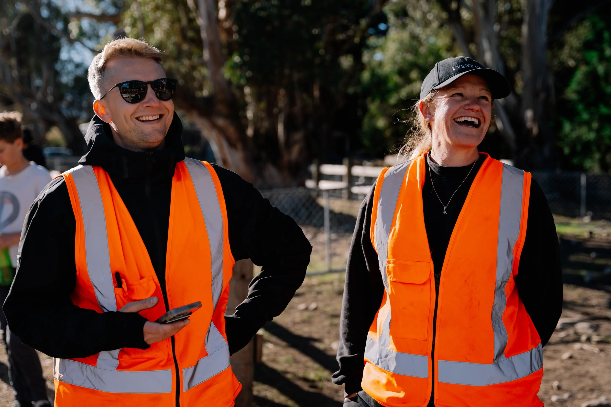 Two Event Goals team members wearing orange high-visibility vests outdoors