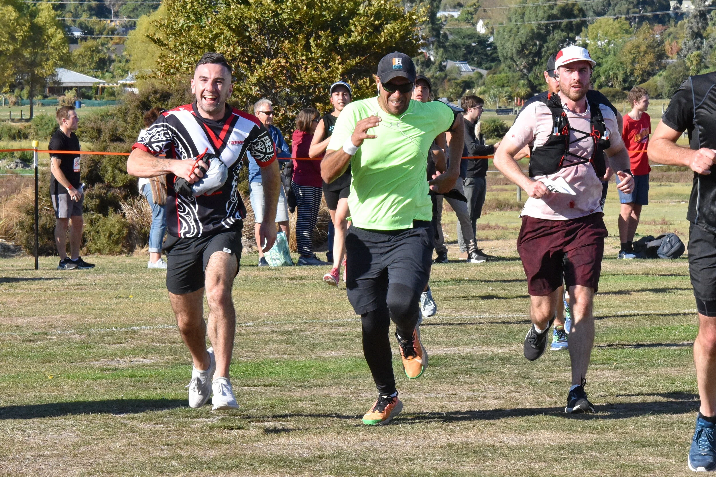 City2Surf participants running across the grass near spectators