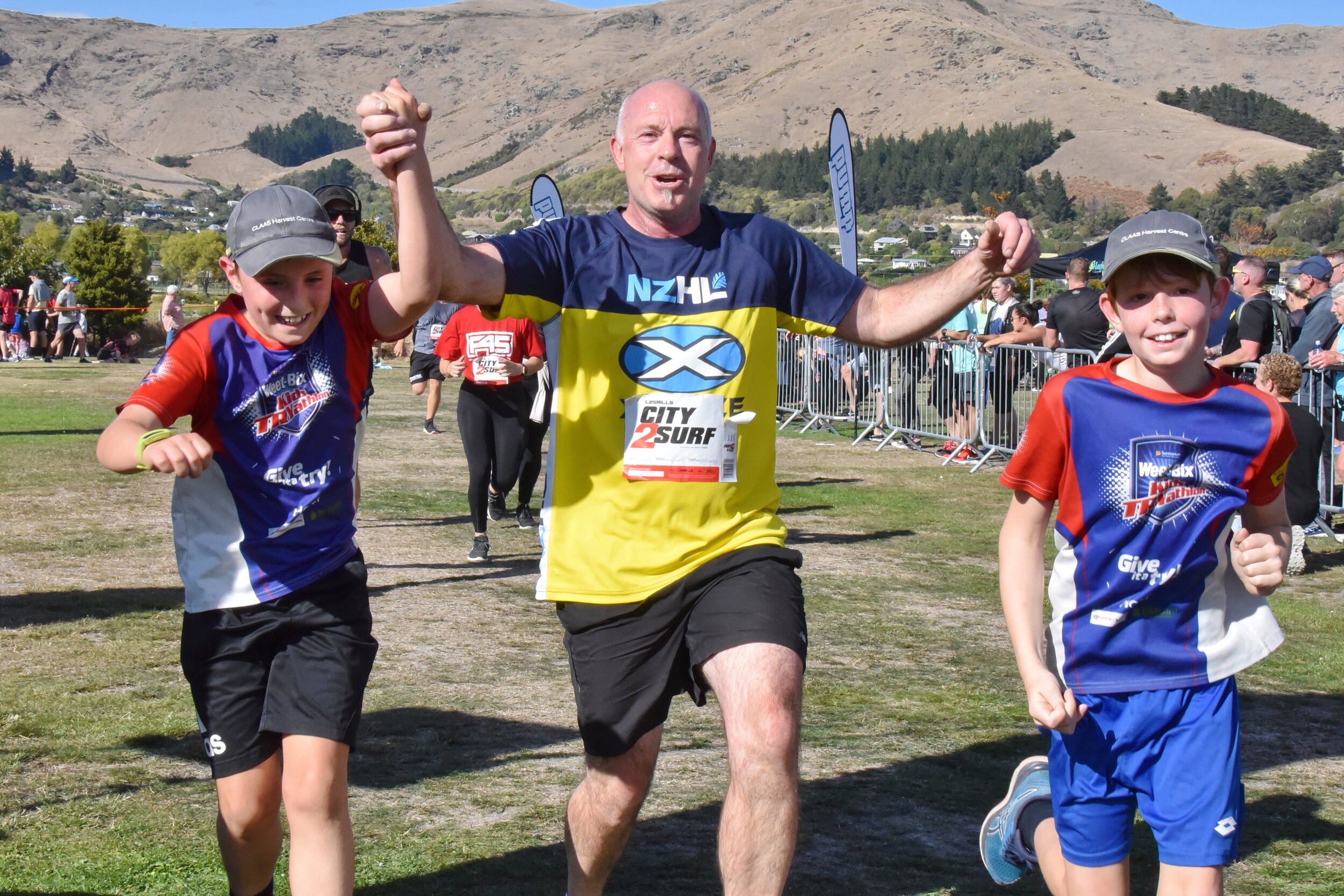 An adult and two children running together at City2Surf