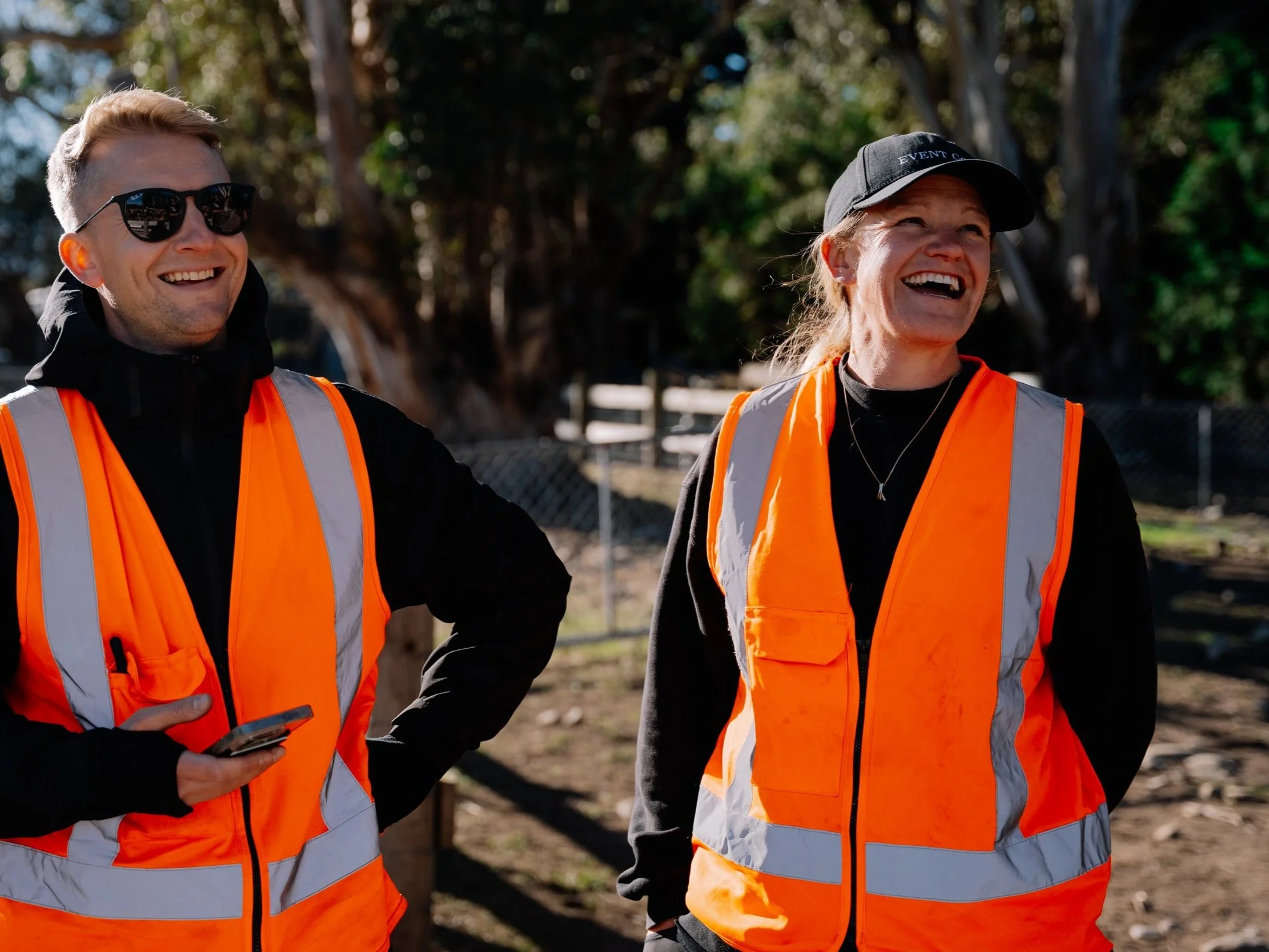 Two Event Goals team members wearing orange high-visibility vests outdoors