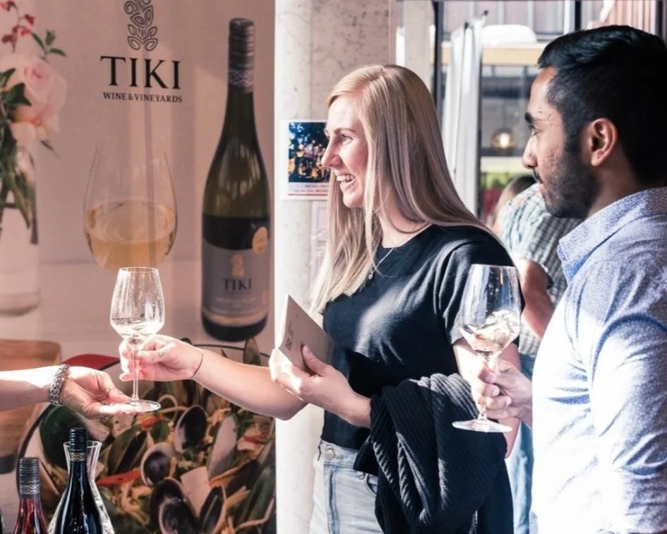 Guests sampling wine at an indoor tasting stand