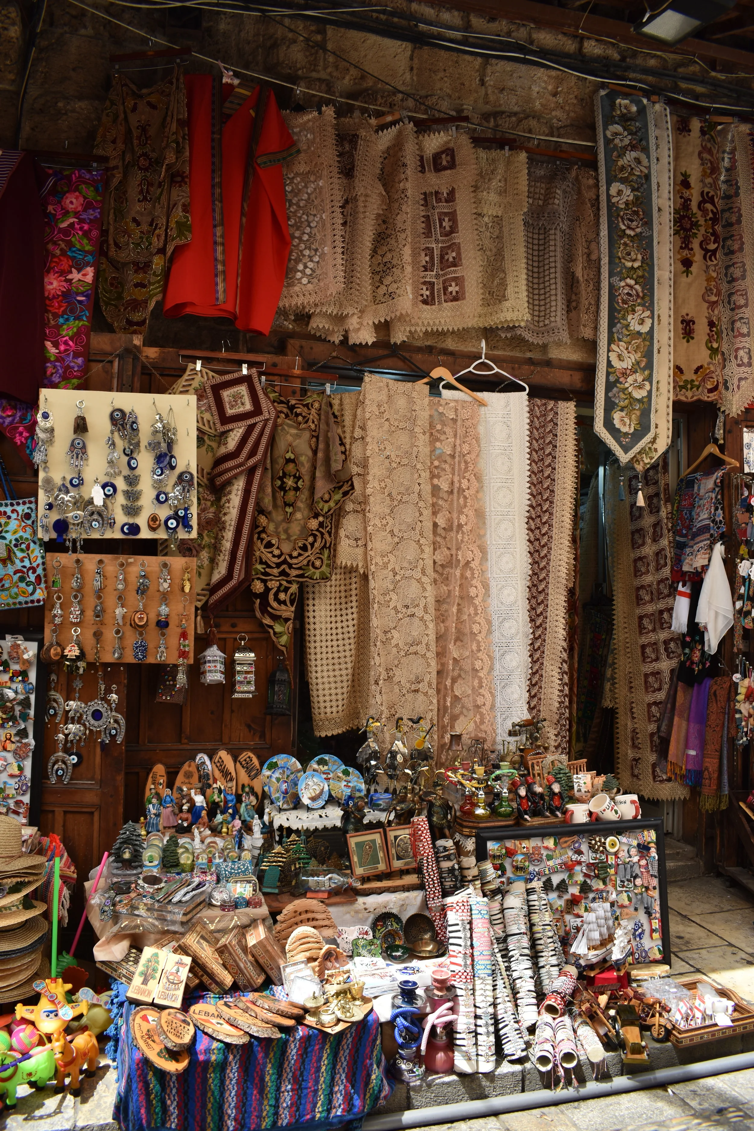 Clothing, textiles, jewelry, and souvenirs displayed in an outdoor market stall.